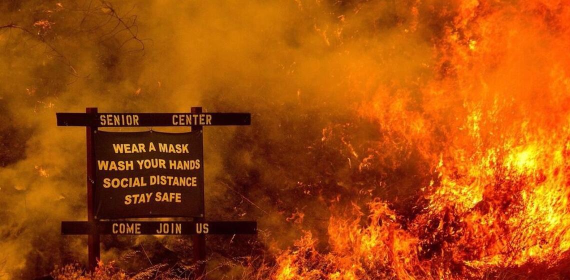 Wildfire with COVID restrictions sign