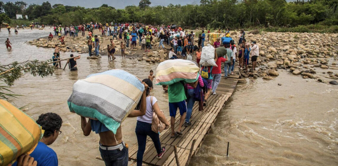 People crossing over a flooding river
