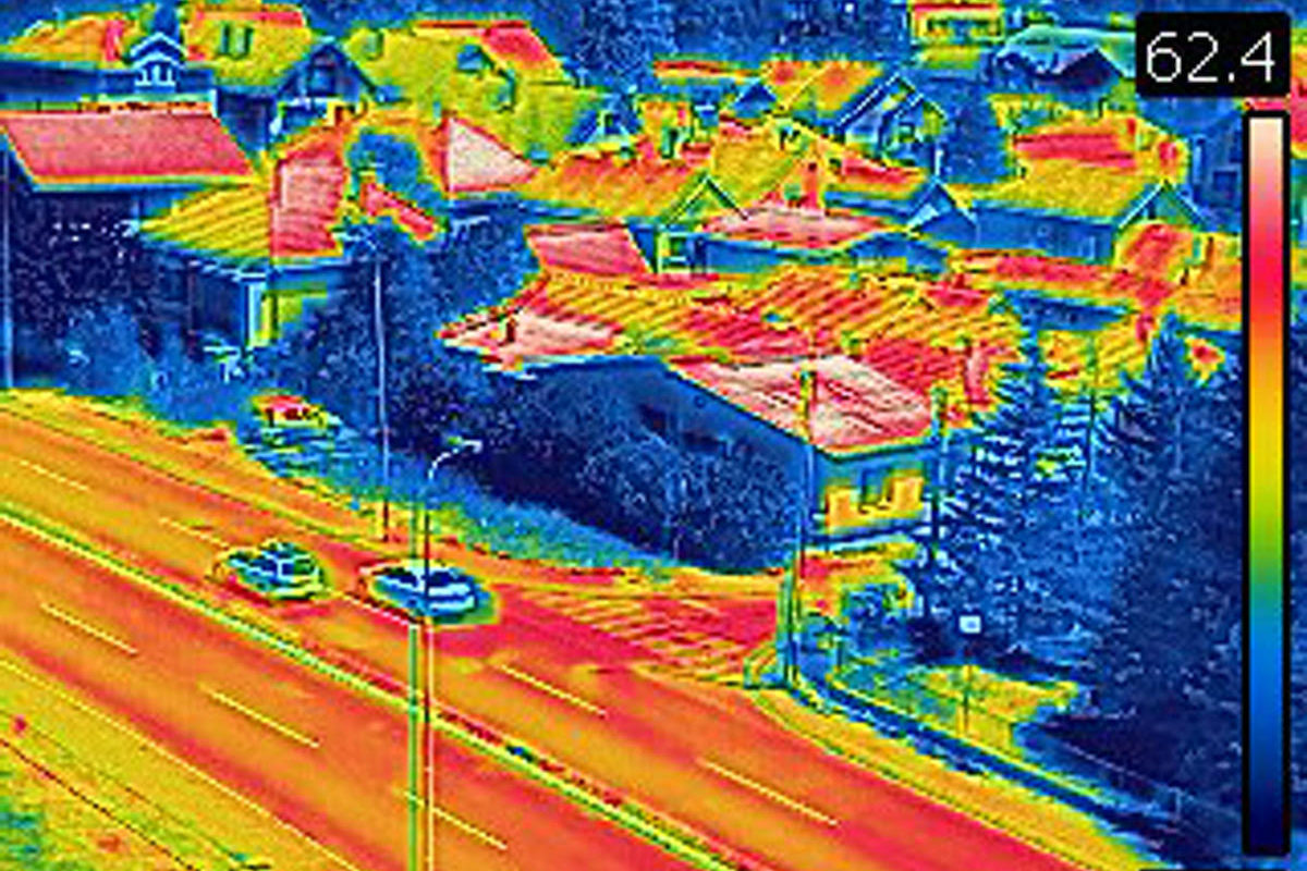 Image of street taken with infra red camera. Each color represents different temperatures, as is shown on spectrum scale on right side of image. Temperature in upper left corner is temperature of point where cursor is.
